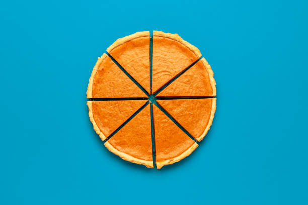 istock Sliced pumpkin pie top view, minimalist on a blue table 1689119925