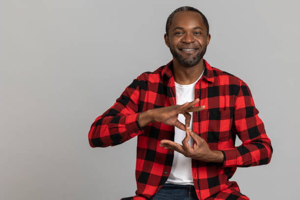 istock Cheerful black bearded man wearing red checkered shirt showing deaf-mute gestures 1689149954