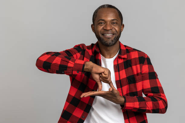 istock Cheerful black bearded man wearing red checkered shirt showing deaf-mute gestures 1689149955