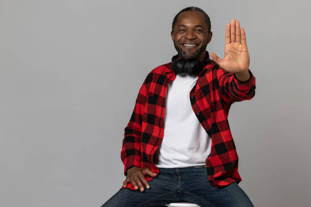 istock Smiling black bearded man wearing red checkered shirt showing stop gesture 1689151227