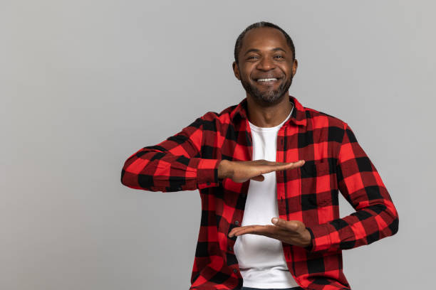 istock Cheerful black bearded man wearing red checkered shirt showing empty space between hands 1689151632