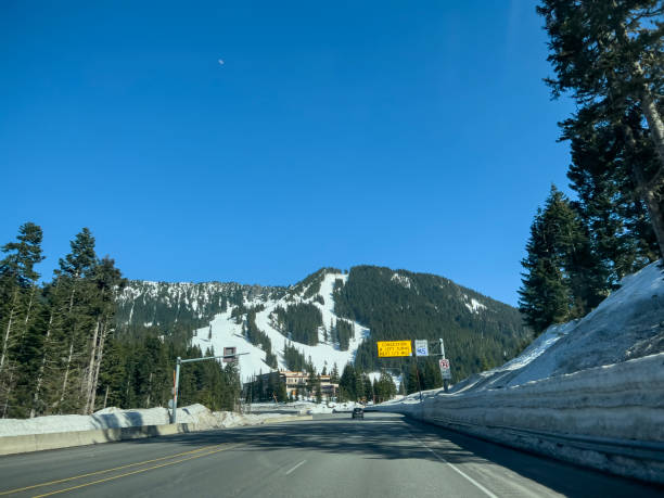 Wide view of the mountain pass in late spring on a sunny day. Stevens Pass, WA USA - circa April 2023: Wide view of the mountain pass in late spring on a sunny day. north cascades national park cascade range waterfall snowcapped stock pictures, royalty-free photos & images