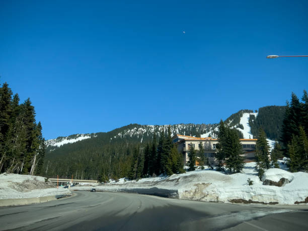 Wide view of the mountain pass road leading to Stevens Pass Ski Resort. Stevens Pass, WA USA - circa April 2023: Wide view of the mountain pass road leading to Stevens Pass Ski Resort. north cascades national park cascade range waterfall snowcapped stock pictures, royalty-free photos & images