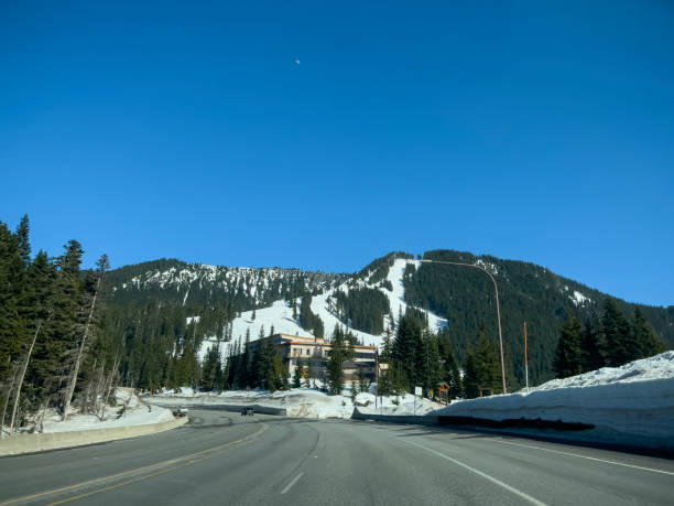 Wide view of the mountain pass road leading to Stevens Pass Ski Resort. Stevens Pass, WA USA - circa April 2023: Wide view of the mountain pass road leading to Stevens Pass Ski Resort. north cascades national park cascade range waterfall snowcapped stock pictures, royalty-free photos & images