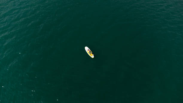 istock Young adult laying on a stand up paddleboard (SUP) 1689173020