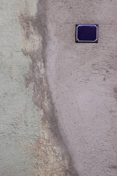 istock Gray greenish old shabby cracked cement wall with the classical design house empty number plate. Beautiful antique house concrete wall texture. Front view. Copy space. 1689185227