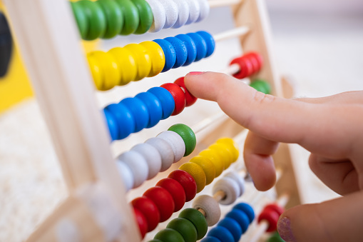 Small fingers on the colorful abacus.
