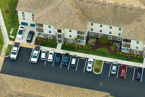 Aerial view of cars parked on parking places at american apartment building in Florida residential area. New family condos as example of housing development in US suburbs.