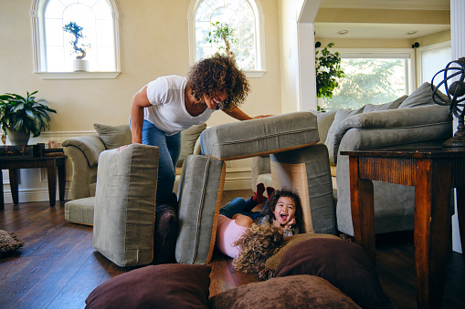 Two little girls, playing in the living room of a home on a play date.