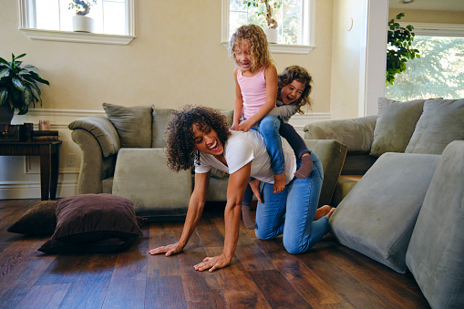 Two little girls, playing in the living room of a home on a play date.