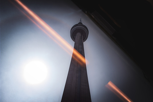 September, 2023- Toronto, Canada: View on the Canadian National -CN- Tower (a communications tower), taken from inside the UP Train (The express train that runs from Toronto Pearson Airport to Union Station) with light effects from inside the train visible in the window.
