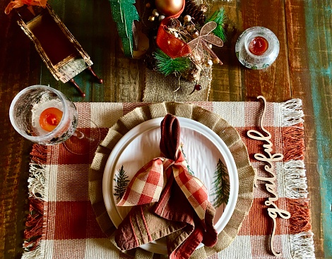 Christmas Dining Tablescape. Rustic in design with wooden trees, centerpiece, candles, napkins and place setting.  Wooden 