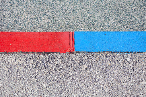 Red and blue line on the asphalt road. Abstract background and texture for design