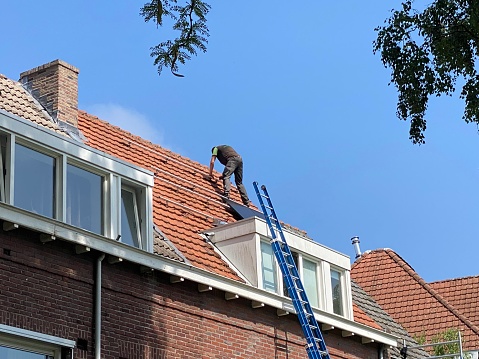 Brunssum  the Netherlands, - September 05,  2023.  Finishig tuch Installing Solar panels on a residential building for a durable energy consumption.