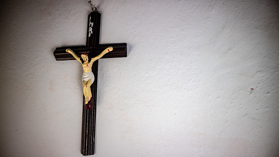 a cross hung on a white wall