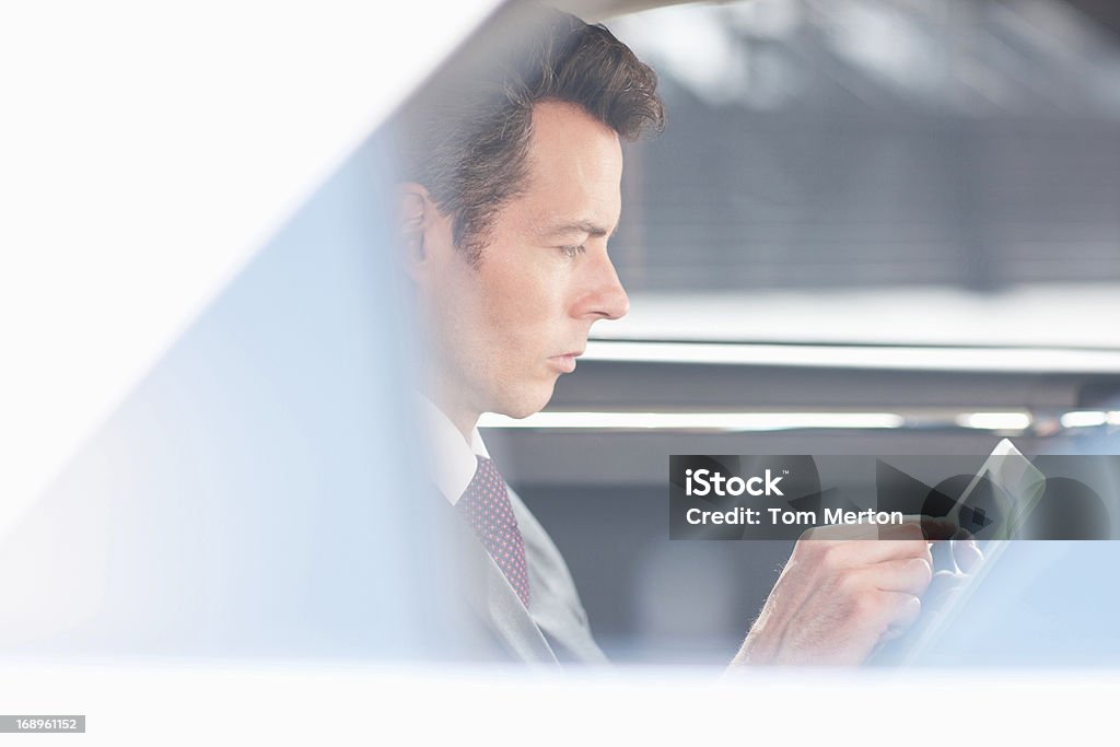 Homem de negócios com computador tablet em backseat de aluguer - Royalty-free 40-44 anos Foto de stock
