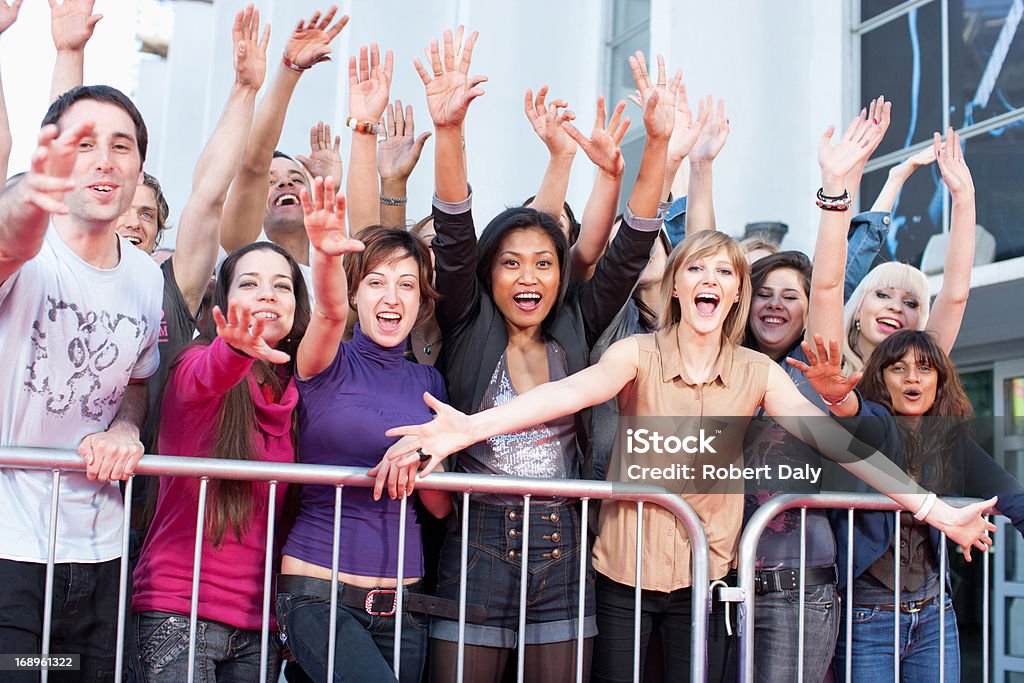 Фанаты размахивающий лапами из-за ограждение - Стоковые фото Толпа роялти-фри