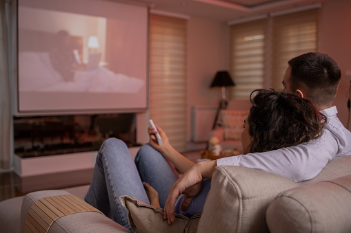 Young couple is watching a movie together in their home theater