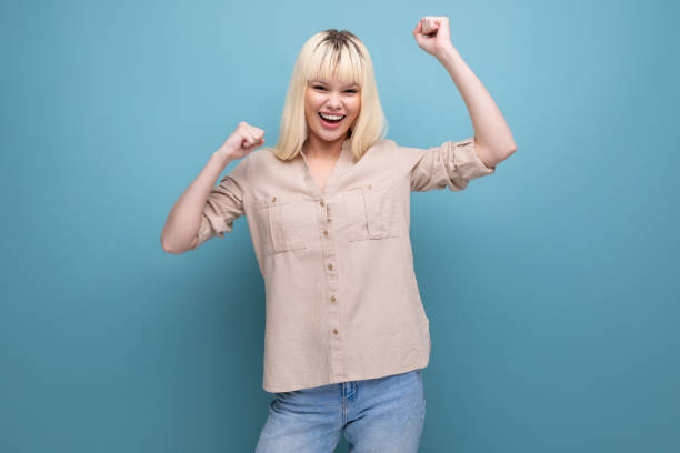 istock cheerful blond young woman in shirt on studio blue background 1689712925