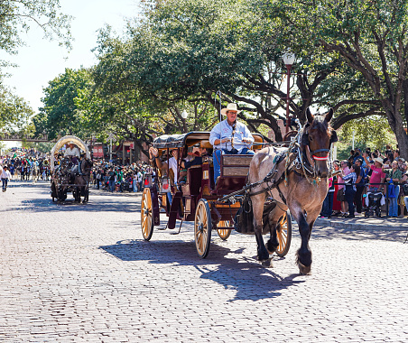 Fort Worth, Texas, USA - September 17, 2023: A horse drawn carriage followed by a covered wagon in the National Hispanic Heritage Month Parade at Fort Worth Stockyards.