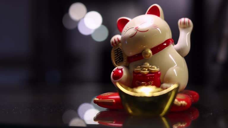 Maneki neko cat waving with paw close up