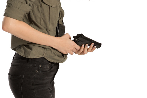 female hand holding a gun on white round . A gun in a female hand. defense or attack murder or armed robbery, First person view of a pistol.