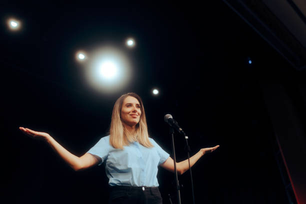 istock Woman Standing on a Stage Speaking on the Microphone 1689871147