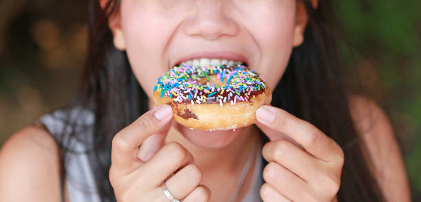 istock Asian woman enjoy eating rainbow donut. 1689888537