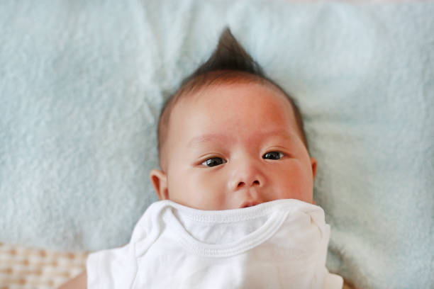 istock Cute infant baby boy in towel lying on bed after bath. 1689912297