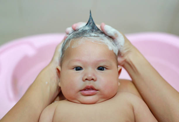 istock Infant baby boy is being bathed and shampooed by mother. 1689915529