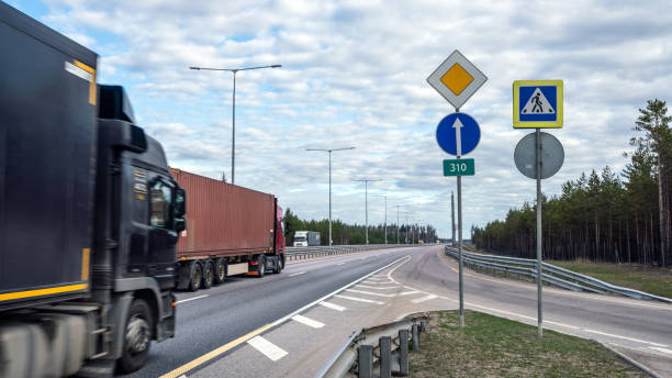 lastwagen auf mehrspuriger autobahn. güterverkehrskonzept. - driving industry land vehicle multiple lane highway stock-fotos und bilder