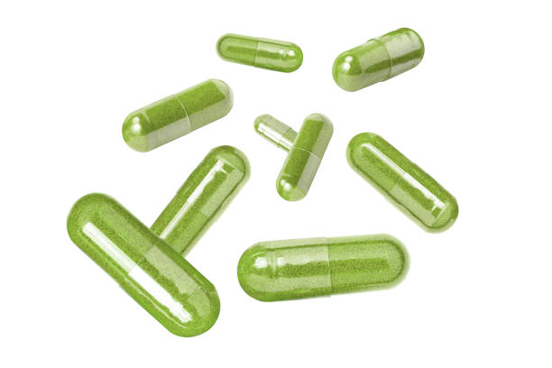 istock Green herbal powder capsule levitate isolated on white 1689921890