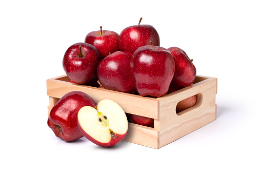 Red apples in wooden crate isolated on white background.
