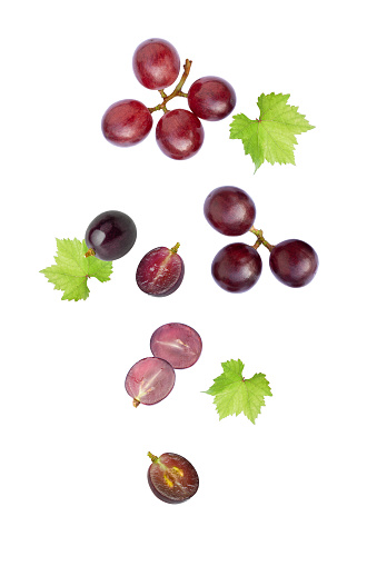 Red grape with leaf falling isolated on white background.