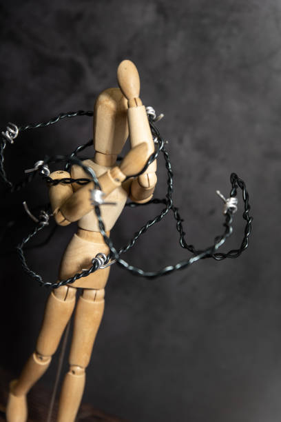 istock wooden mannequin holding its head, surrounded by wire 1689956613