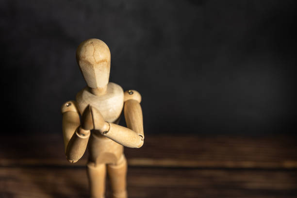 istock wooden mannequin holding its head, black background 1689957164