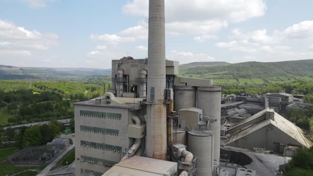 Aerial drone flight around the main building of Breedon Hope Cement Works with a panoramic view of Mam Tor in Castleton