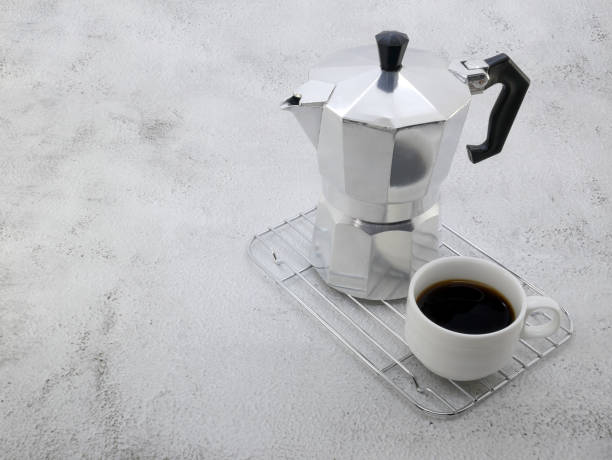 istock Coffee maker moka pot and a cup on stone background. 1689986427