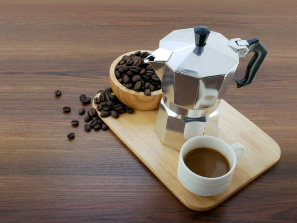 istock Coffee maker moka pot and a cup on wooden background. 1689987989