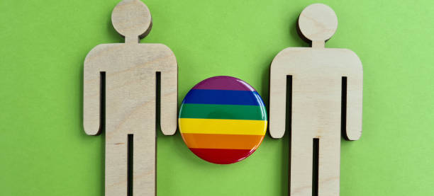 istock Two figures with a rainbow flag. Gay community 1689990141