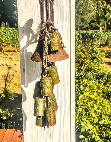 An antique bell hangs on a post in the bright sun.