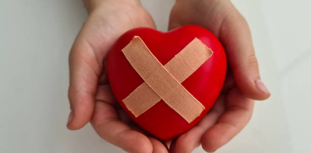 istock Child holds broken heart sealed with band-aid 1689991671