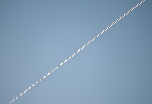 Tokyo, Japan -September 19, 2023: Contrail drawn by a big cargo airplane at dawn