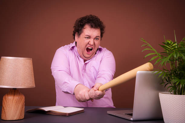 istock Funny fat man posing at a table with a laptop. Hard work online early morning 1690027308