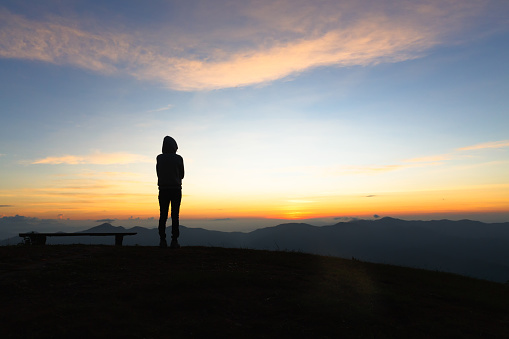 silhouette woman standing on mountain in morning and vintage filter, Feast hiking. Deep thought. Fall sunset.Person watch.Spring sun. Person watch sky miracles.