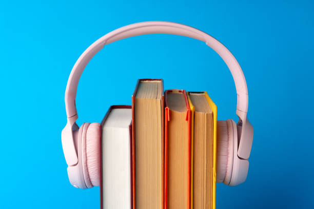 istock Pink headphones on stack of books against blue background 1690096871