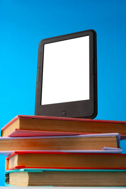 istock Modern e-book on stack of hardcover books on blue background 1690102781