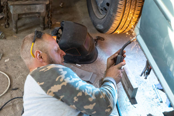 o mecânico de automóveis profissional usa uma máquina de solda para reparar um carro. - car bodywork flash - fotografias e filmes do acervo