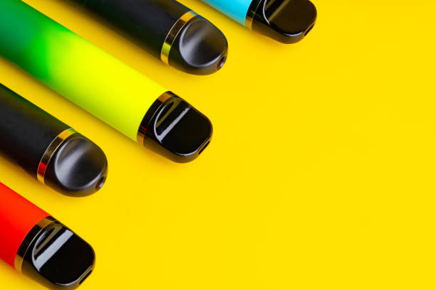 istock Colorful disposable electronic cigarettes on yellow background 1690108078