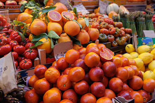 Traditional green and food market stall with citrus fruit and fresh vegetables in Bologna, Italy